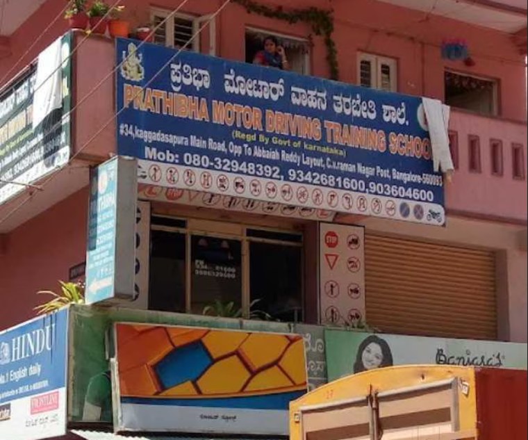 The Prathibha Motor Driving Training School signboard above shops on Kaggadasapura Main Road, Bengaluru